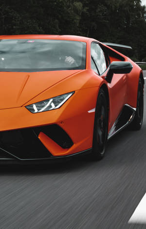 橙色林寶堅尼 Huracán 在賽道上奔馳，帶有動態模糊效果。