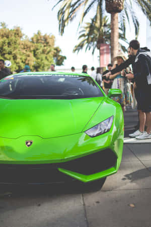 一輛亮綠色的林寶堅尼 Huracán 停在行人路上，有旁觀者觀看。