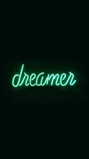 一個綠色霓虹燈牌寫著 dreamer，對著黑色牆壁。 — 霓虹 iPhone 壁紙