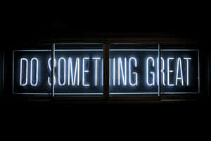 一個明亮的白色霓虹燈牌，在黑暗中寫著「DO SOMETHING GREAT」。