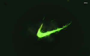 螢光綠色Nike剔號標誌，在黑暗背景上帶有發光粒子