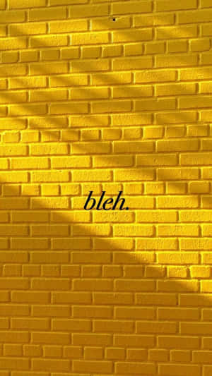 黃色磚牆，帶有樹葉陰影和優雅字體的「bleh」。