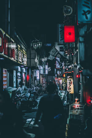 夜晚東京小巷，霓虹招牌和街燈照亮，行人剪影。