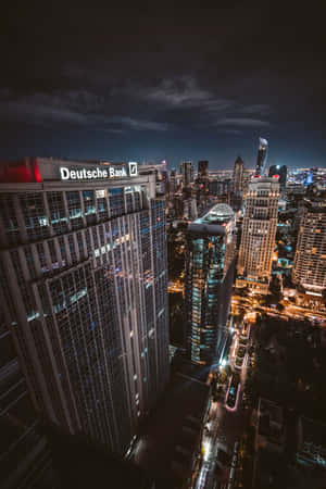 夜間城市天際線，高聳的建築物燈火通明，街道繁忙。 — POCO Pad 壁紙