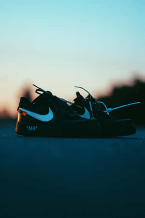 黑色Nike Air Force 1運動鞋，白色swoosh和橙色標籤，暮色窗台。 — 2:3 壁紙