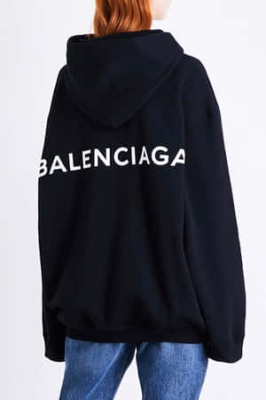 穿著黑色 Balenciaga 連帽衛衣和藍色牛仔褲的人，從後方觀看。