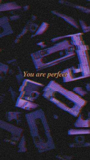 散落的卡式錄音帶上帶有故障效果和「you are perfect」文字。