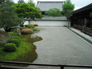 日本花園，有碎石小徑、苔蘚和粉紅色花朵，靠近木建築 — 4:3 壁紙