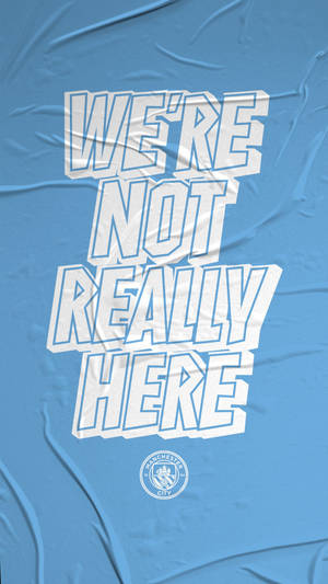 文字圖形，藍色布料上寫著「WE'RE NOT REALLY HERE」，附有曼城標誌。