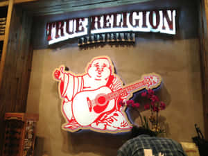 True Religion Jeans商店招牌，有卡通佛陀彈結他和粉紅色蘭花。