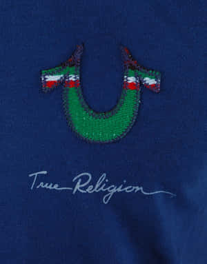 藍色T恤，帶有綠色刺繡U標誌和True Religion簽名。