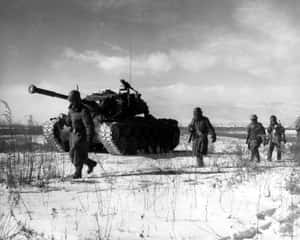 士兵在雪地中靠近坦克行走。 — 戰爭 壁紙