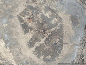 乾燥沙漠山谷的衛星圖像，包含道路和建築物。