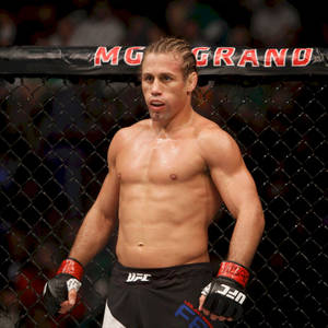 一個赤裸上身的MMA拳手穿著UFC裝備在八角籠內。