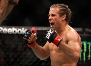 MMA拳手在八角籠中握緊拳頭慶祝勝利。