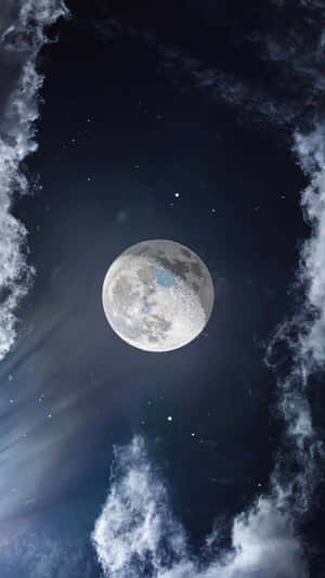 滿月在繁星夜空下透過飄動的雲層發光。