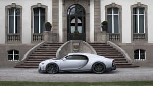 銀色 Bugatti Chiron 停泊在一座宏偉的石砌大宅前，配有拱形窗戶和對稱樓梯。