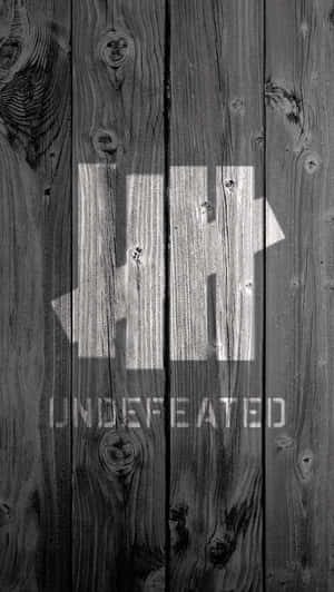 灰色木牆，上有粗體白色文字寫著 undefeated
