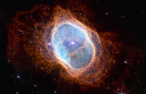 一個發光的宇宙星雲，藍色中心，橙色觸手，周圍環繞著星星。 — 太空 壁紙
