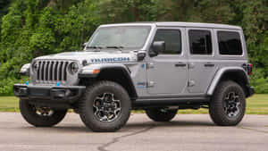 銀色Jeep Rubicon停在行人路上，後面有綠樹。