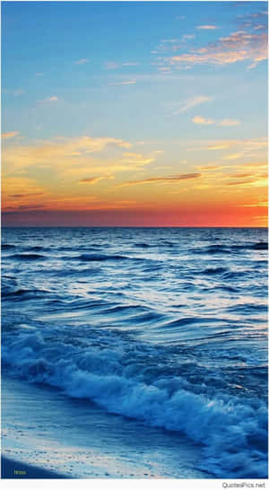 在充滿活力的夕陽天空下，海浪拍打著海岸。
