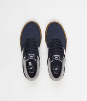 深藍色New Balance運動鞋，黑色橡膠鞋底和白色品牌標誌，從上方展示。