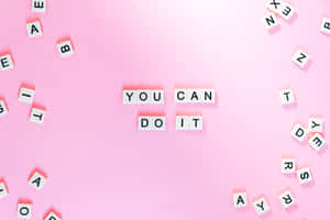 粉紅色背景上，白色字母瓷磚拼出「YOU CAN DO IT」，周圍散落著字母。 — 窩心語錄 壁紙