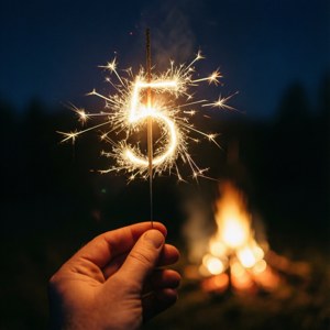 夜晚在營火旁，手拿著一個閃閃發光的數字五形煙花。