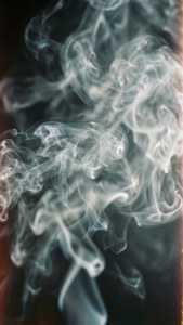在深色漸變背景上以溫暖色調旋轉的白色煙霧。