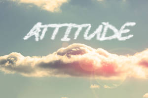雲朵在天空中拼出「attitude」，帶有溫暖陽光和鏡頭光暈。