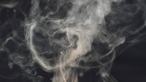 在黑暗背景上旋轉的白色煙霧