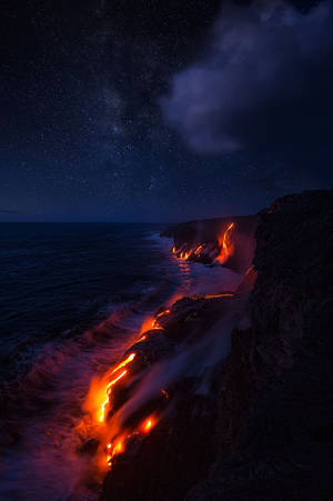 熔岩在繁星點點的夜空下流入海洋。 — 藍天 壁紙
