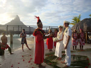 一對情侶在海灘上結婚，背景有山。
