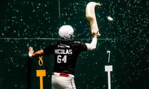 回力球球員Nicolas 64在室內球場揮動cesta球拍擊球。