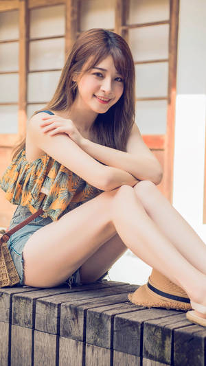 年輕女性坐在戶外木長椅上微笑。