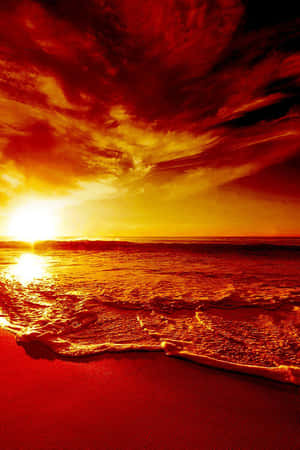 強烈的紅色和橙色夕陽映照在海浪上，沖刷著沙灘。 — 小米Mix 壁紙