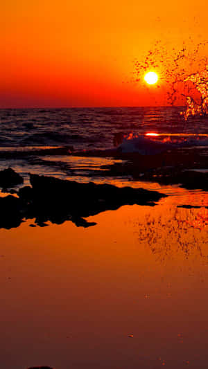 海洋上的夕陽，海浪拍打岩石和橙色倒影 — 日出 壁紙