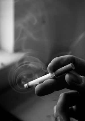 手拿著點燃的香煙，煙霧在周圍盤旋，黑白畫面。 — 黑白 壁紙