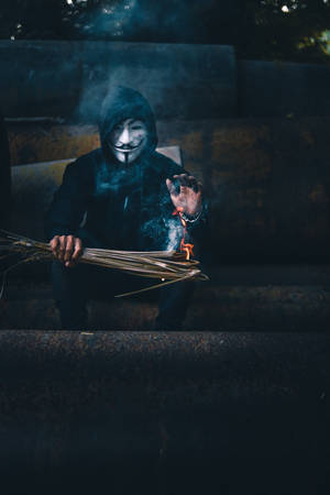戴著蓋伊·福克斯面具的人在夜晚的生鏽金屬樓梯上手持燃燒的香。 — 鬼滅之刃面具 壁紙