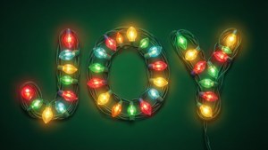 在深綠色背景上，由發光的燈串形成的「joy」這個詞。