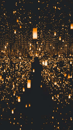 夜晚被漂浮的金色燈籠包圍的人的剪影。