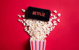 Netflix手機被條紋桶中的爆谷包圍，紅色背景