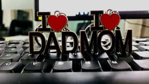 電腦鍵盤上的兩個 I heart DAD 和 I heart MOM 鑰匙扣。