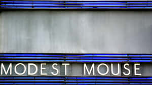 夜晚灰色建築物外牆上的 Modest Mouse 霓虹燈牌。