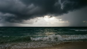 暴風雨的海浪在烏雲下拍打沙灘