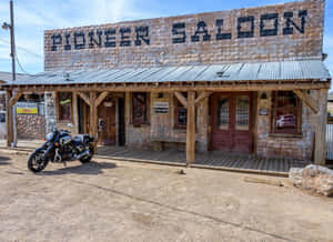 電單車停泊在沙漠環境中的 Pioneer Saloon 前。