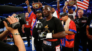 拳擊手特倫斯·克勞福德在拳擊擂台上用冠軍腰帶慶祝勝利。