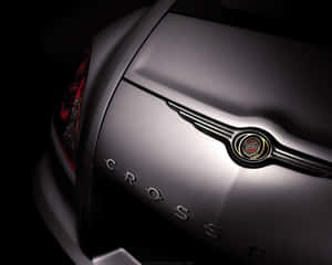時尚銀色 Chrysler Crossfire 車尾，帶有鍍鉻徽章和發光尾燈，處於黑暗環境中。 — 5:4 壁紙