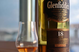 Glenfiddich 18年威士忌酒瓶與裝滿琥珀色液體的品酒杯。