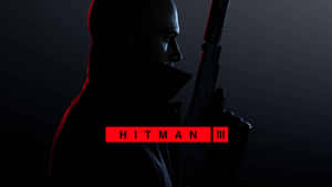 穿著深色外套的刺客手持步槍，帶有紅色「Hitman III」文字。 — 殺手 壁紙